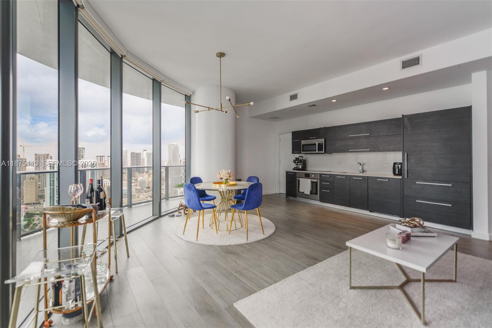 A modern apartment features a kitchen, dining area, and floor-to-ceiling windows with city views — 45 SW 9th ST # 4108, Miami FL 33130, MIAMI, FL