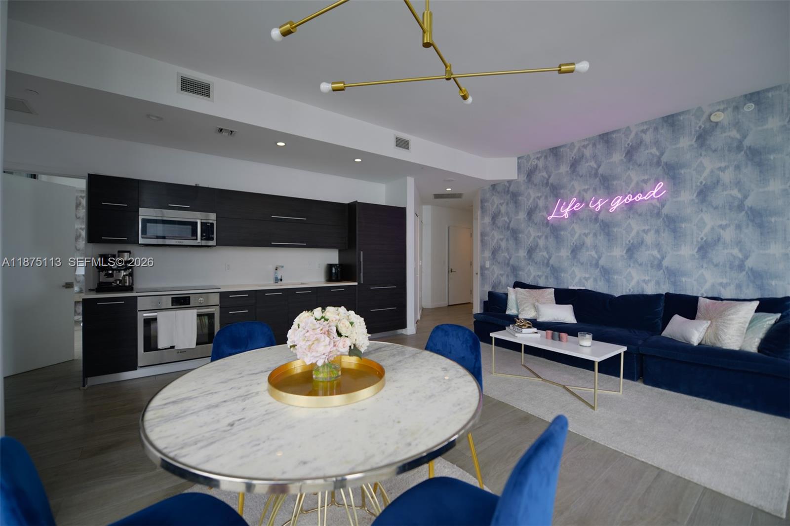 An open-concept living area features a kitchen with dark cabinets, a dining table, and a sofa — 45 SW 9th ST # 4108, Miami FL 33130, MIAMI, FL