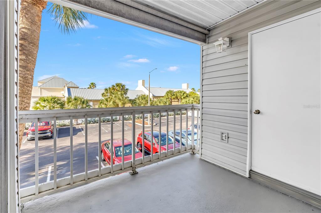 A balcony with a metal railing overlooks a parking lot with several parked cars — 6939 STONES THROW CIRCLE N UNIT 6206, ST PETERSBURG, FL