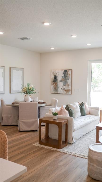 A modern kitchen features white cabinets, stainless steel appliances, and a quartz-topped island with stools — 5837 ANGELA LEYLA PLACE, RIVERVIEW, FL