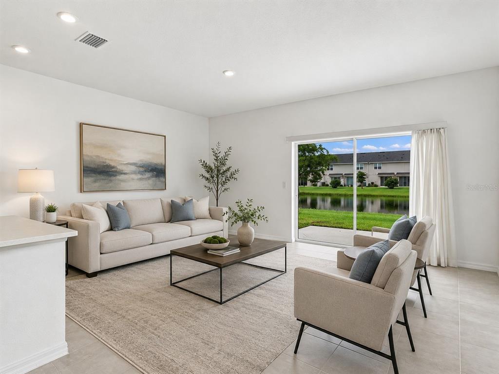 A living room features a beige sofa, two armchairs, a coffee table, and sliding glass doors — 5739 ARCHIPELAGO STREET, NOKOMIS, FL