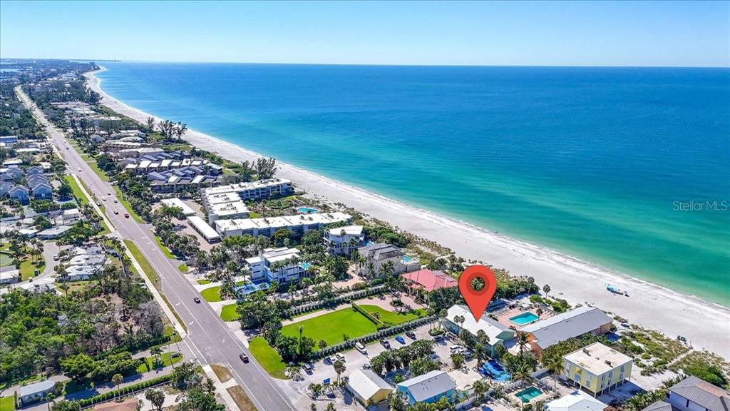 An aerial view shows a coastal resort with a swimming pool near the beach — 5841 GULF OF MEXICO DRIVE UNIT 244, LONGBOAT KEY, FL
