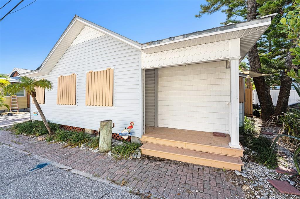 A light blue house with a covered front porch and wooden shutters on the windows — 125 95TH AVENUE, TREASURE ISLAND, FL