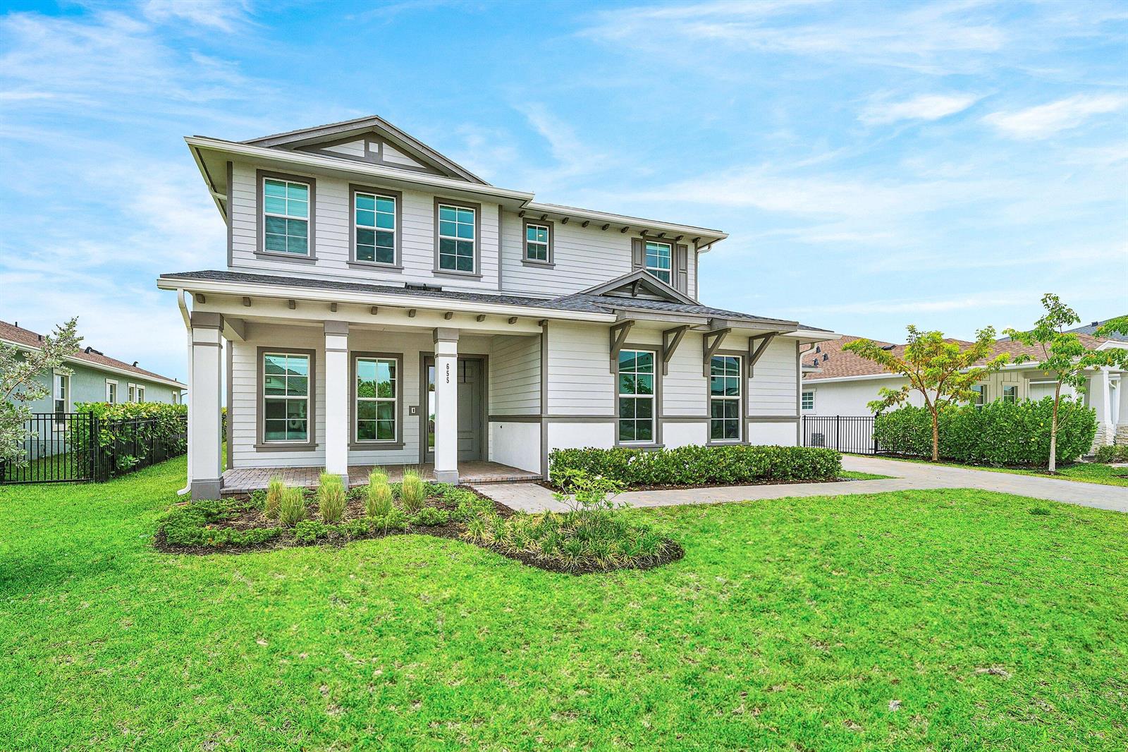 A two-story house with light gray siding, a covered front porch, and a green lawn — 655 Hookline Circle, Loxahatchee FL 33470, LOXAHATCHEE, FL