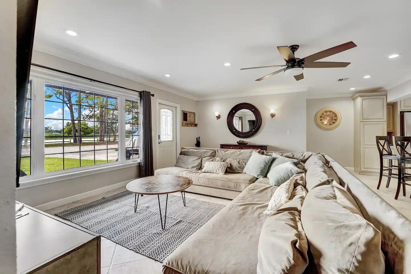 A living room features a large sectional sofa, a round coffee table, and a picture window — 5574 Lake Osborne Drive, Lake Worth FL 33461, LAKE WORTH, FL