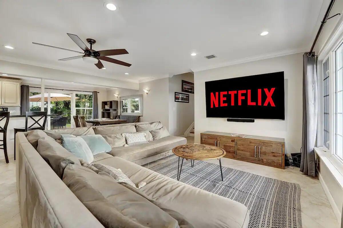 A living room features a large sectional sofa, a television, and a wooden media console — 5574 Lake Osborne Drive, Lake Worth FL 33461, LAKE WORTH, FL