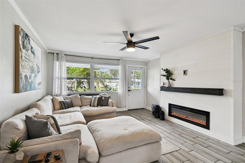 A living room features a sectional sofa, a fireplace, and a ceiling fan — 4722 W BAY AVENUE, TAMPA, FL