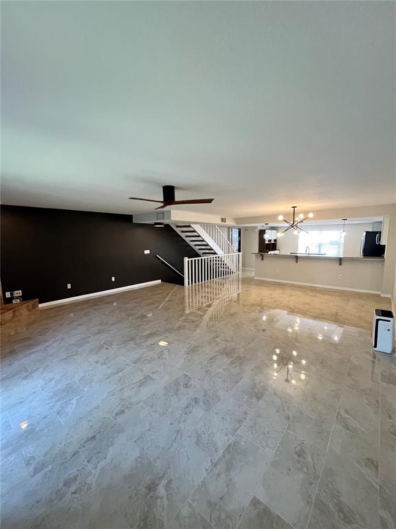 A kitchen features white cabinets, granite countertops, a center island, and tile flooring — 1117 S PINELLAS BAYWAY S UNIT 306, ST PETERSBURG, FL