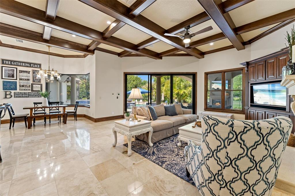 A living room and dining area feature coffered ceilings, tile flooring, and large glass doors — 6004 WINDHAM PLACE, TAMPA, FL