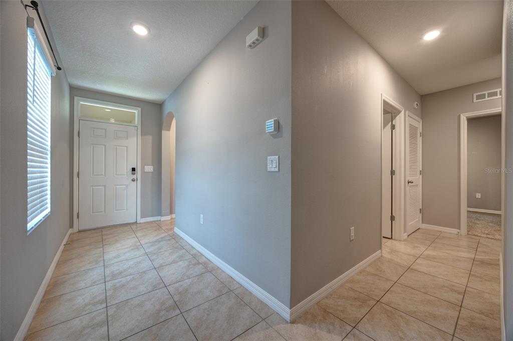 A tiled entryway features a white front door, gray walls, and recessed ceiling lighting — 227 DUKE DRIVE, DELAND, FL