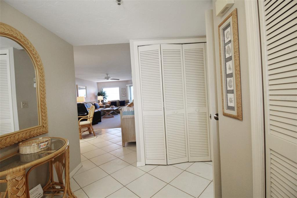 A tiled entryway leads into a living room with a wicker console table and closet doors — 1333 SIESTA BAYSIDE DRIVE UNIT 1333-D, SARASOTA, FL