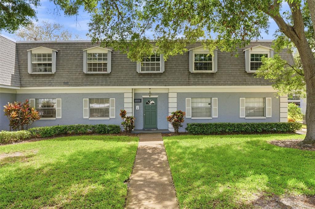 A two-story blue house with a green front door and a concrete walkway — 1715 BELLEAIR FOREST DRIVE UNIT A, BELLEAIR, FL