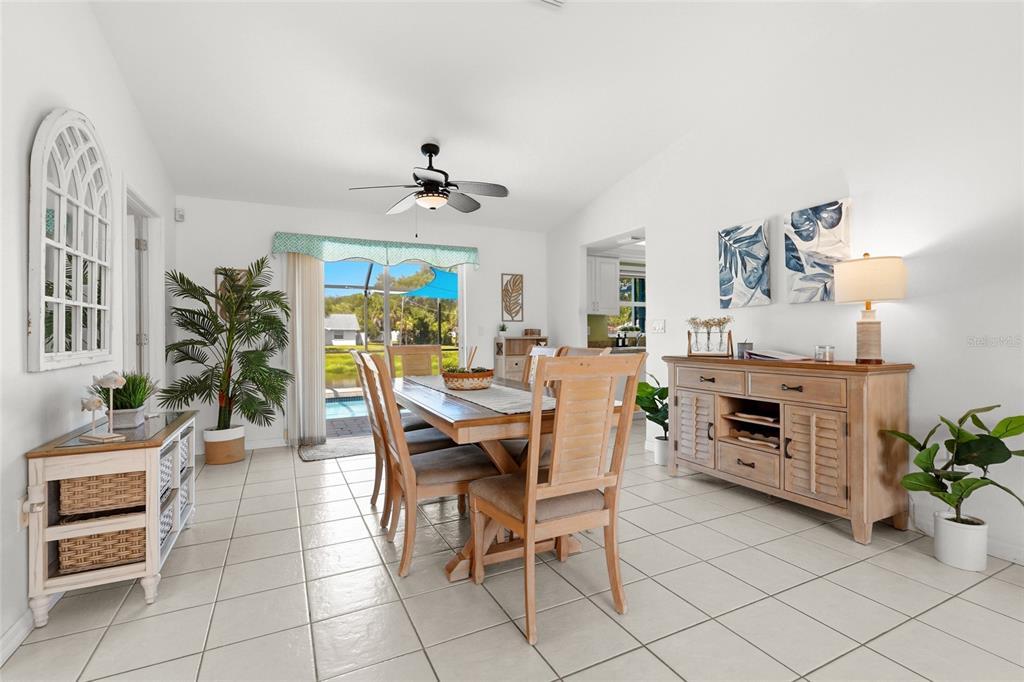 A dining room features tile floors, a wooden table with chairs, and a sliding glass door — 2240 GENTIAN ROAD, VENICE, FL