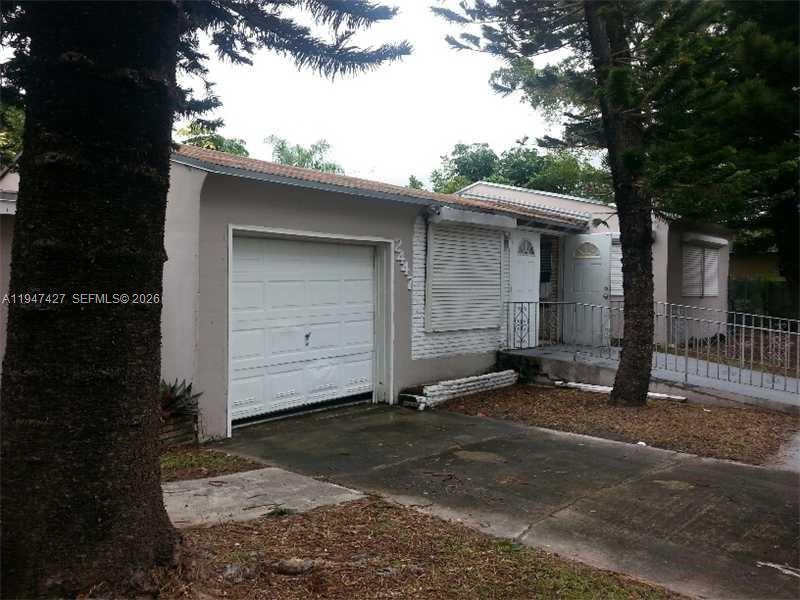 A single-story house with a white garage door, a covered porch, and a concrete driveway — 2447 Pierce St # 1, Hollywood FL 33020, HOLLYWOOD, FL