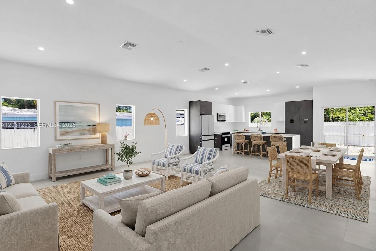 This open-concept living and dining area features white walls, tile flooring, and a modern kitchen — 21 Tina Pl, Key Largo FL 33037, KEY LARGO, FL