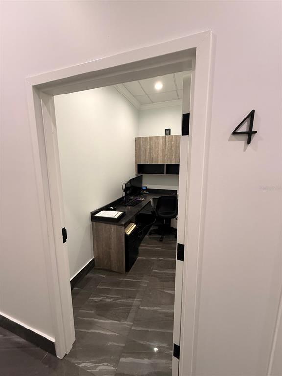 A small office with a desk, chair, and upper cabinets, viewed through a doorway — 7901 KINGSPOINTE PARKWAY UNIT 19 # Office 4, ORLANDO, FL