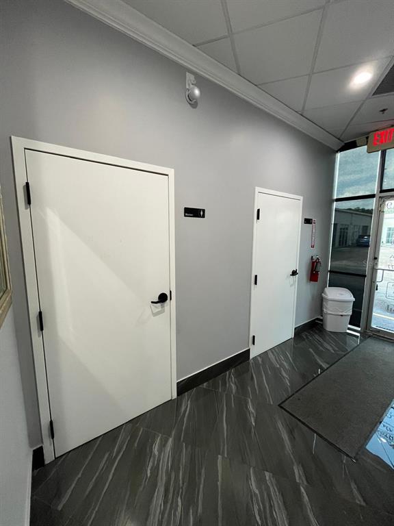 A hallway with two white doors, gray walls, and dark marble-patterned tile flooring — 7901 KINGSPOINTE PARKWAY UNIT 19 # Office 4, ORLANDO, FL