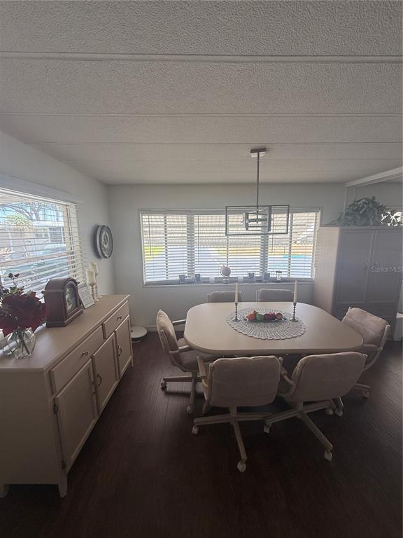 A dining room features a light-colored table with six chairs, a sideboard, and large windows — 7880 54TH AVENUE N UNIT 125, ST PETERSBURG, FL