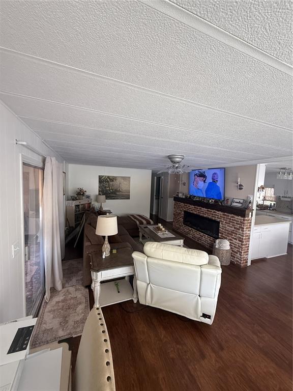 A living room features a brick fireplace, a white recliner, and wood-look flooring — 7880 54TH AVENUE N UNIT 125, ST PETERSBURG, FL