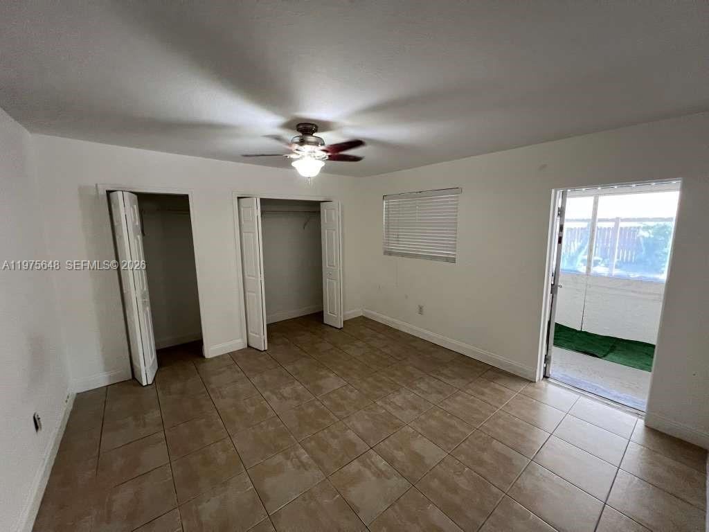 A bedroom features tile flooring, a ceiling fan, two closets, and a door to a patio — 4365 W 1st Ave, Hialeah FL 33012, HIALEAH, FL