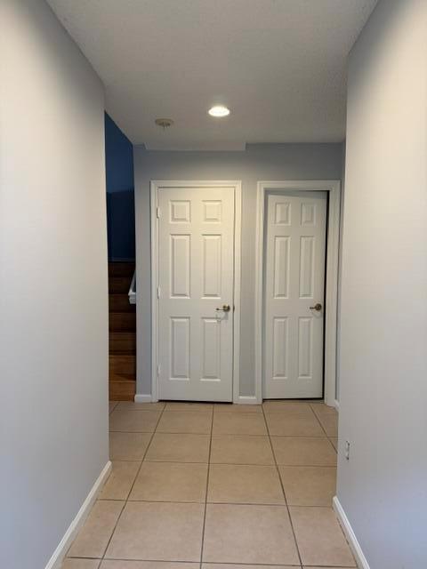 A hallway with light-colored walls and tile flooring leads to two white interior doors — 2440 NW 99th Way, Sunrise FL 33322, SUNRISE, FL