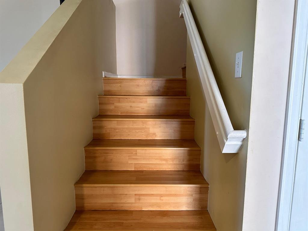 A staircase with light wood-look treads and risers leads upward between two beige walls — 2440 NW 99th Way, Sunrise FL 33322, SUNRISE, FL