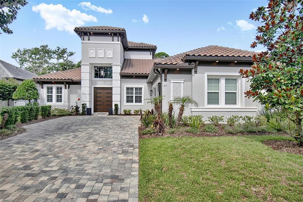 A single-story house with a paved driveway, tile roof, and a prominent entryway tower — 23 N RIVERWALK DRIVE, PALM COAST, FL