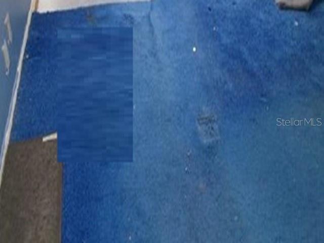 A room features blue carpeting with a patch of different flooring in the corner — 6190 WOODLANDS BOULEVARD UNIT 309, TAMARAC, FL
