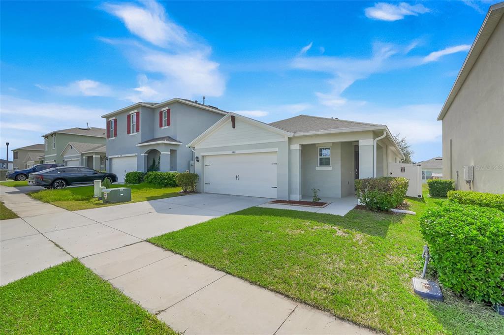 A single-story suburban house with a two-car garage and a front lawn — 3881 BRANT PLACE, LEESBURG, FL