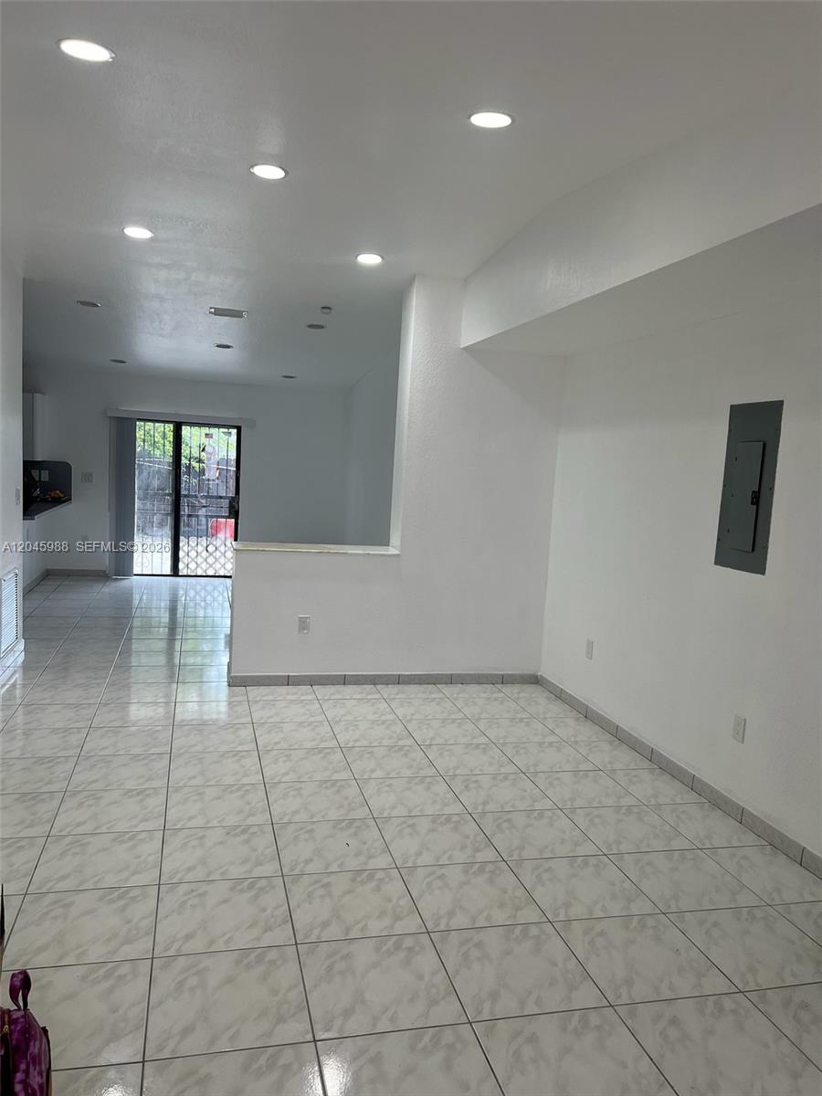 An open-concept room features white tile flooring, recessed lighting, and a view of a kitchen — 11461 SW 193rd St # 0, Miami FL 33157, MIAMI, FL