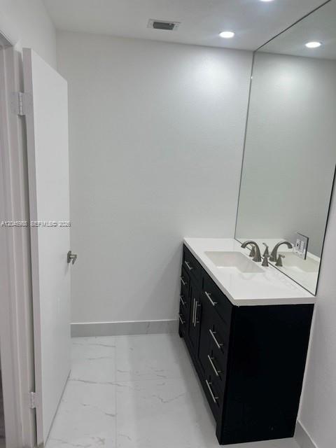 A bathroom features a black vanity with a white countertop and a large wall mirror — 11461 SW 193rd St # 0, Miami FL 33157, MIAMI, FL