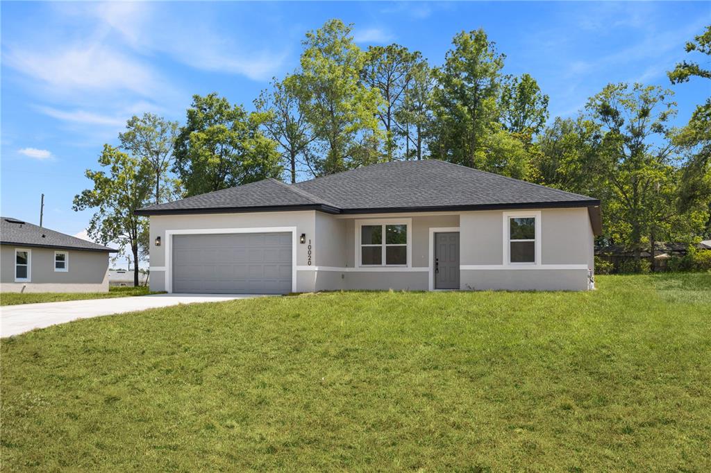 A single-story house with a gray exterior, a two-car garage, and a grassy front yard — 44 W GULFSTREAM PLACE, CITRUS SPRINGS, FL