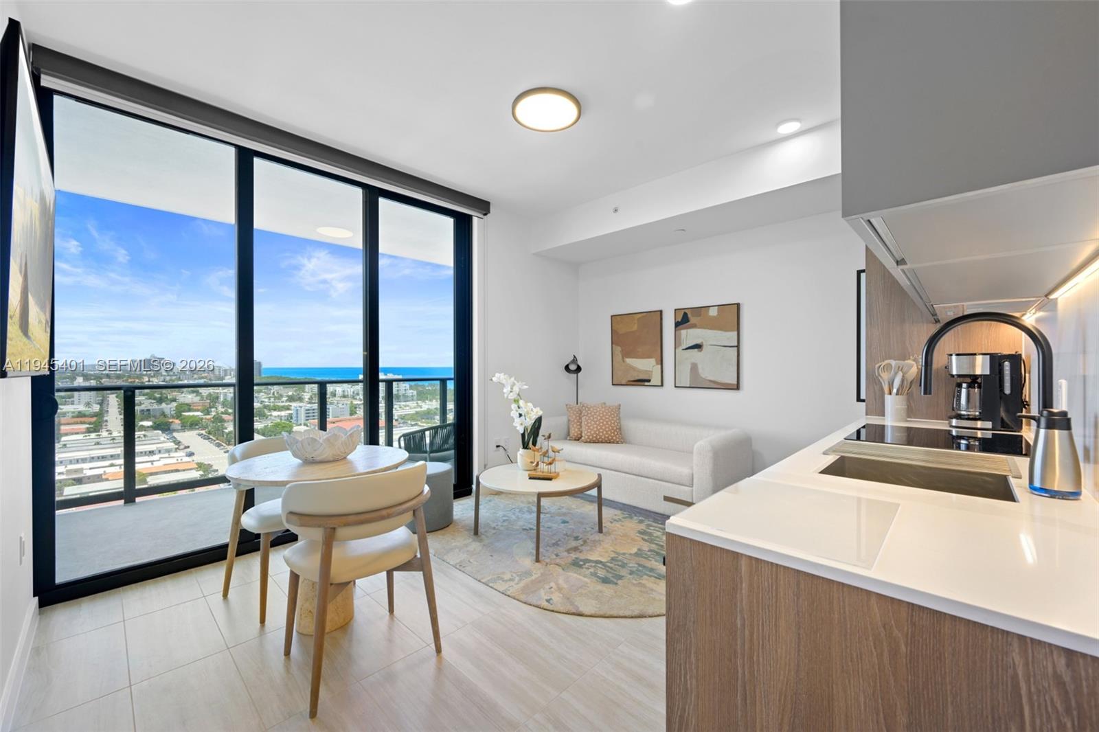 A modern studio apartment features a kitchen, dining area, living space, and a balcony view — 580 72nd St # 1603, Miami Beach FL 33141, MIAMI BEACH, FL