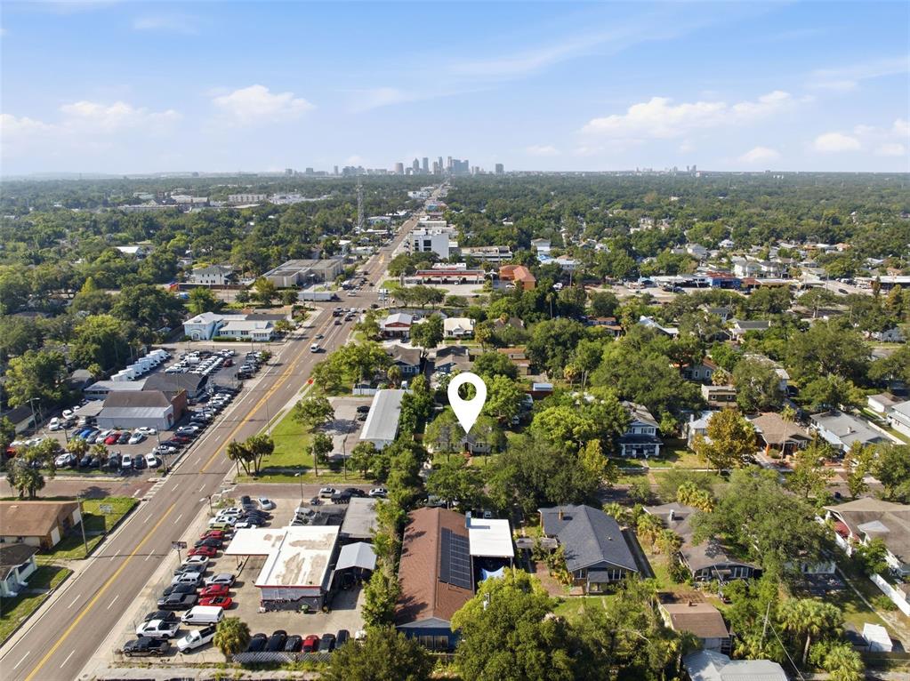 A light-colored, single-story house with a brick chimney stands behind a grassy front yard — 106 W COMANCHE AVENUE, TAMPA, FL