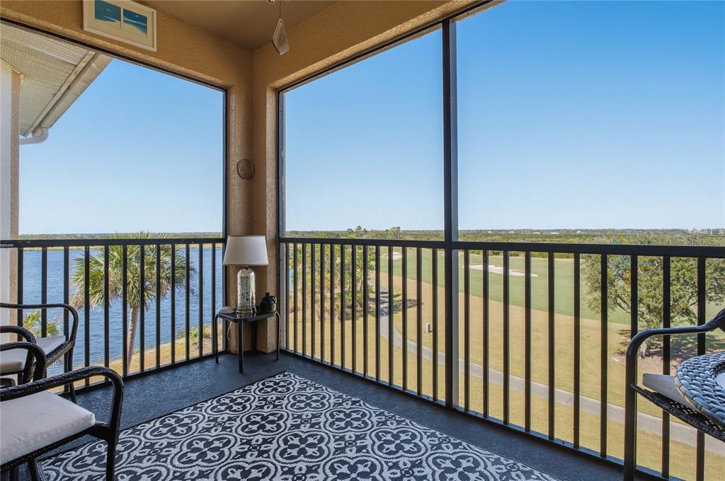 A screened-in balcony overlooks a lake and a golf course on a sunny day — 8105 GRAND ESTUARY TRAIL UNIT 402, BRADENTON, FL