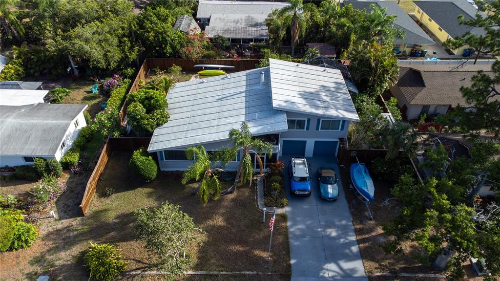 An aerial view shows a house with a metal roof, driveway, and fenced yard — 2719 FORT WORTH STREET, SARASOTA, FL
