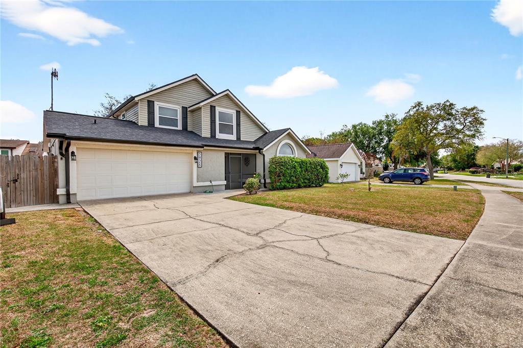 A two-story house with a cracked concrete driveway, a two-car garage, and a front lawn — 5928 BOGGS FORD ROAD, PORT ORANGE, FL