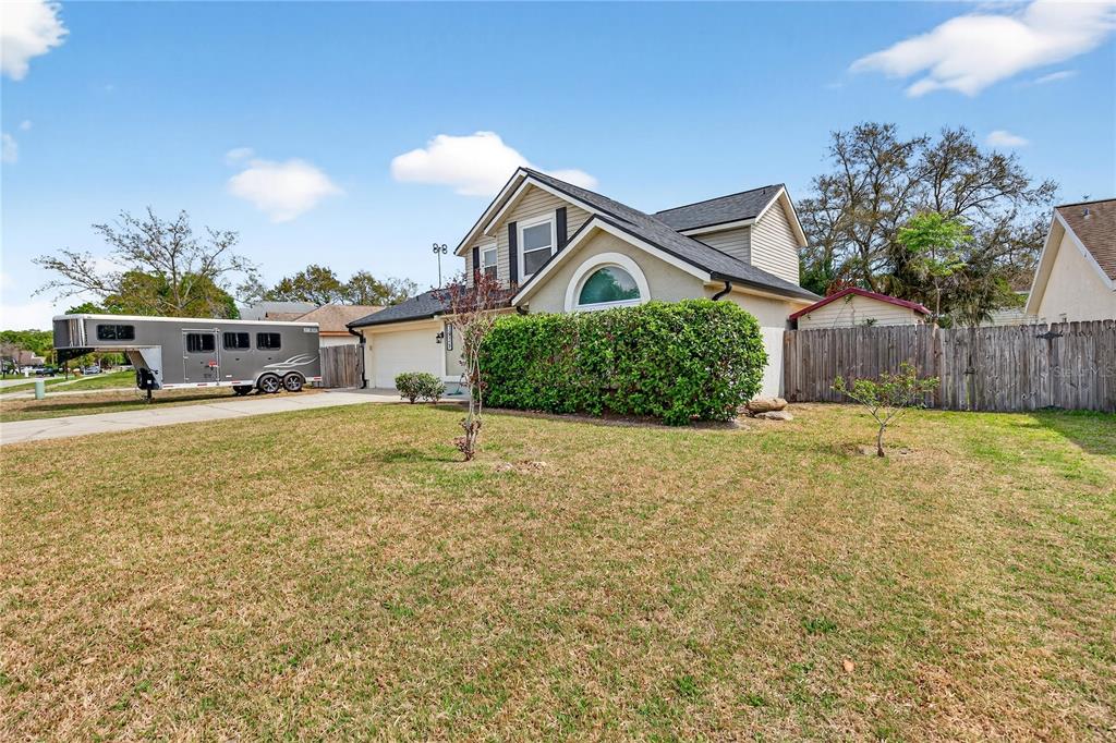 A two-story house with a large hedge, a driveway, and a horse trailer parked outside — 5928 BOGGS FORD ROAD, PORT ORANGE, FL
