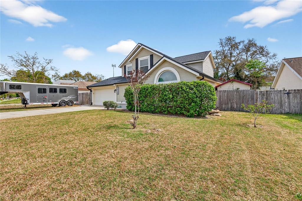A two-story house with a large hedge, a driveway, and a horse trailer parked outside — 5928 BOGGS FORD ROAD, PORT ORANGE, FL