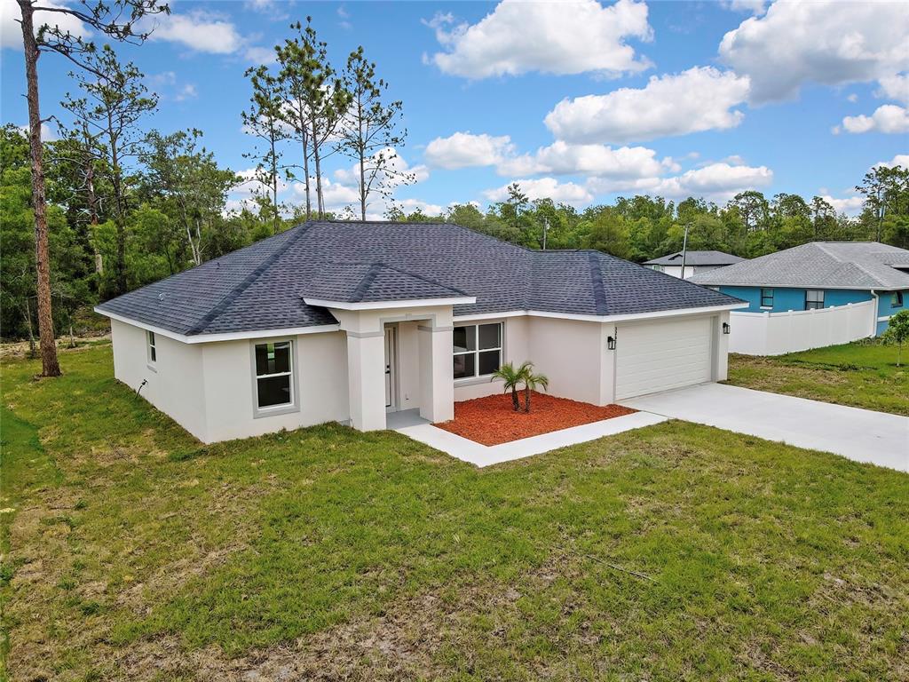 A single-story house with a white stucco exterior, dark shingled roof, and a two-car garage — 3261 W VIKING LANE, CITRUS SPRINGS, FL