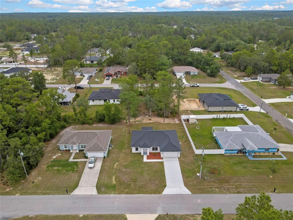 An aerial view shows several suburban houses surrounded by trees and grassy lots — 3261 W VIKING LANE, CITRUS SPRINGS, FL