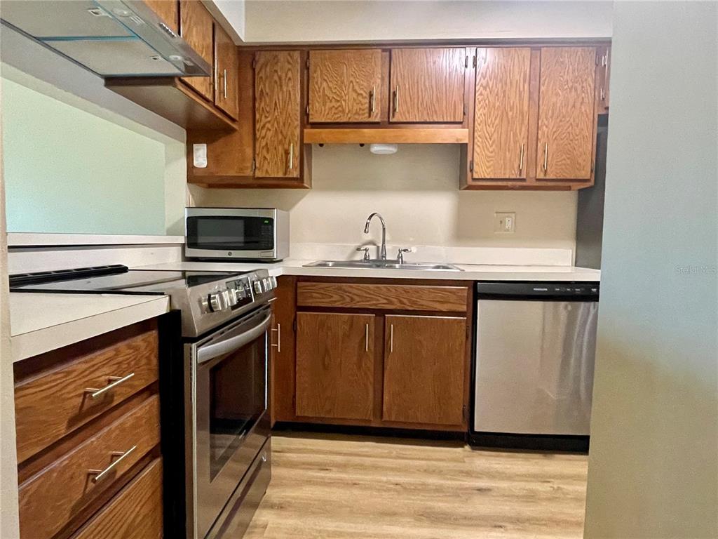 A kitchen features wood cabinets, stainless steel appliances, and light-colored countertops — 2341 ARUBA COURT, KISSIMMEE, FL