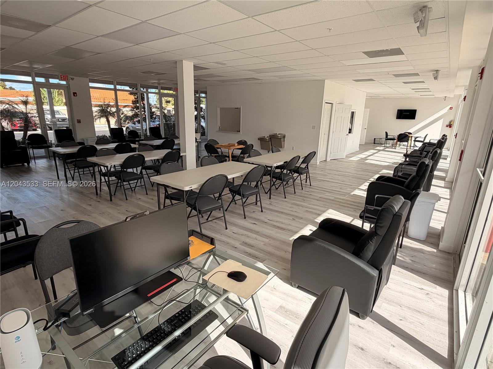 A bright, open office space features rows of tables, chairs, and a computer workstation — 665 E 49 ST, Hialeah FL 33013, HIALEAH, FL