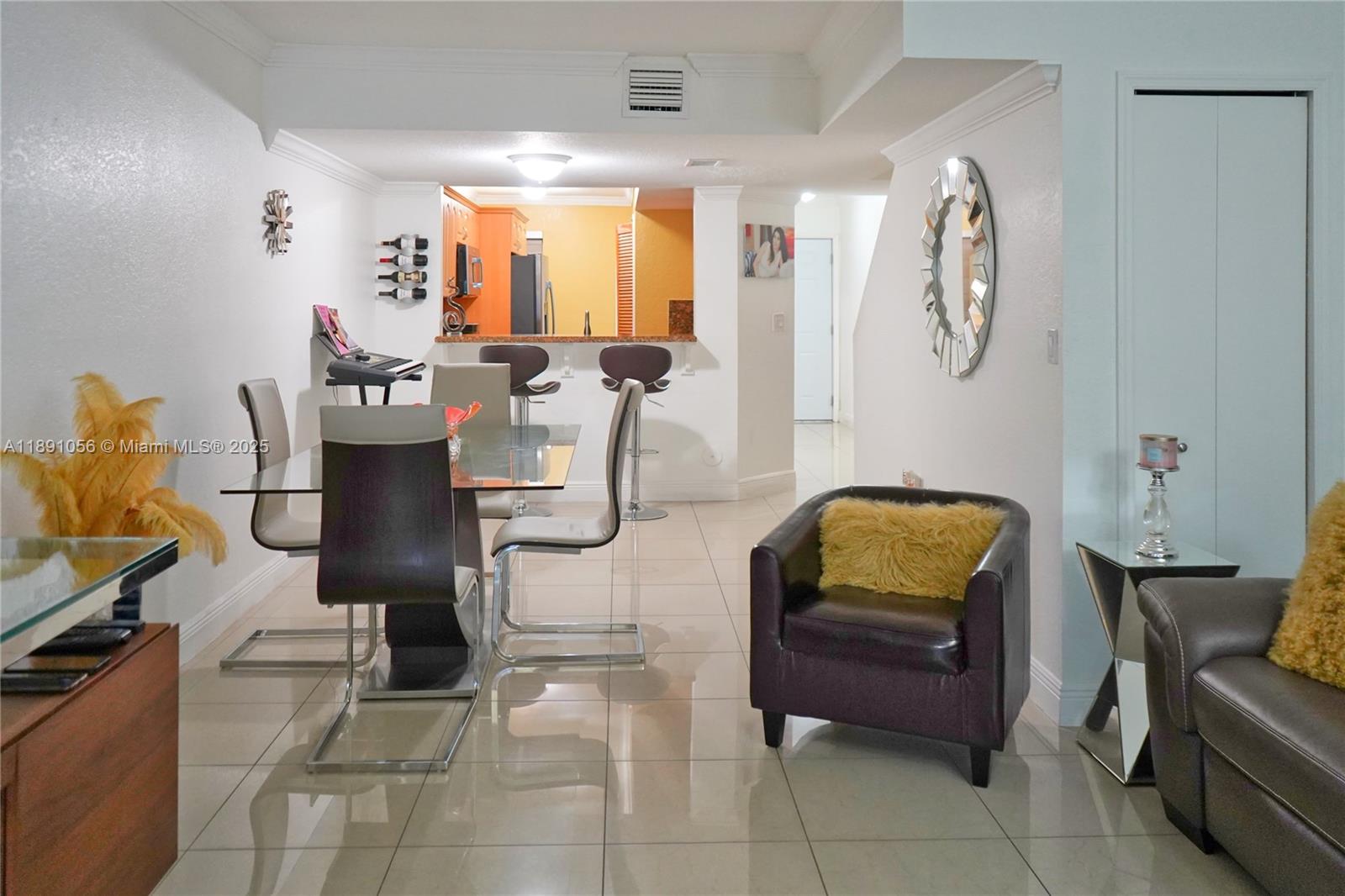 A dining area with a glass table and chairs sits adjacent to a kitchen counter — 1195 NW 124th Ave # 2202, Miami FL 33182, MIAMI, FL