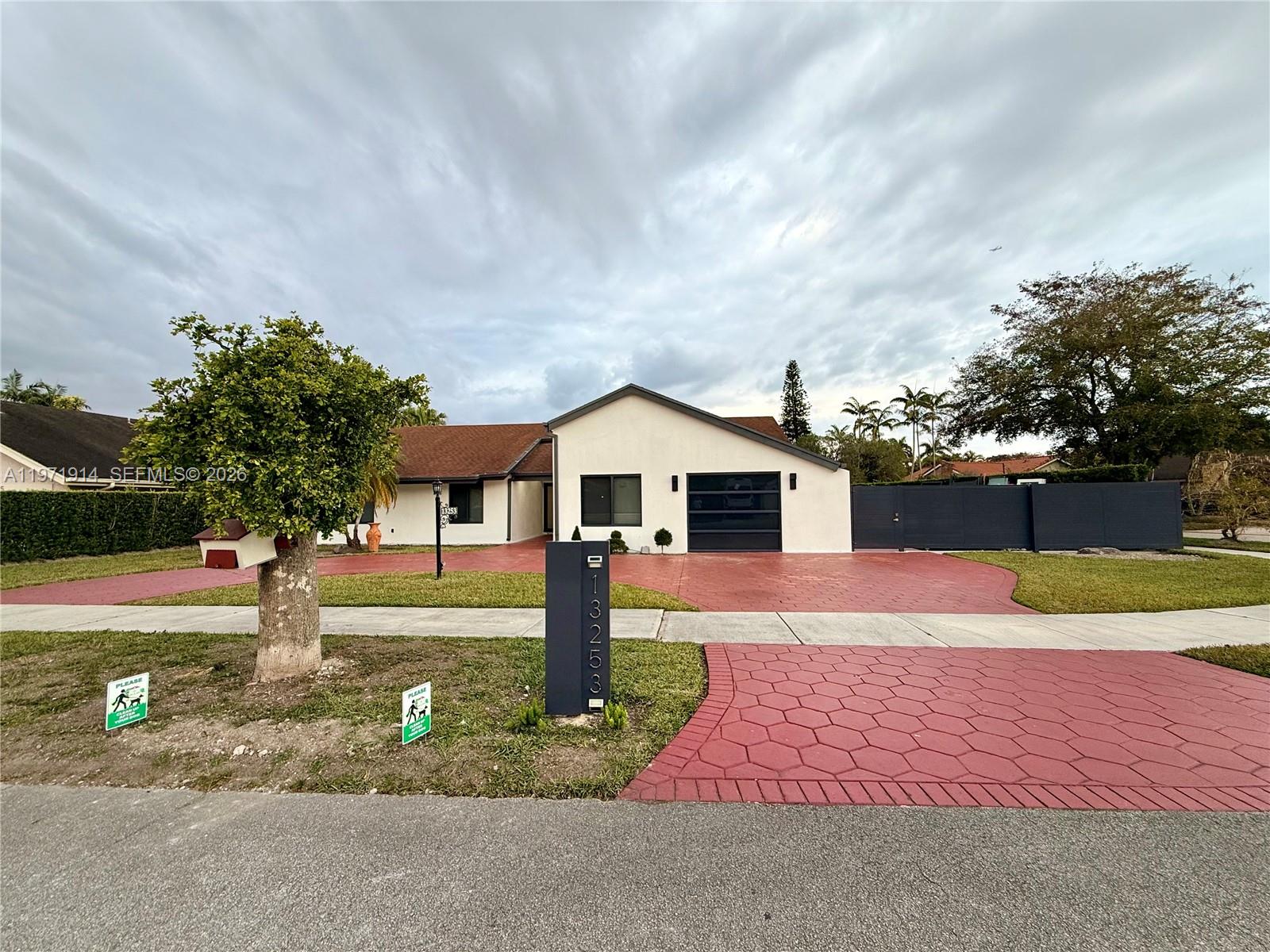 A single-story house with a red stamped concrete driveway and a modern address pillar — 13253 SW 96th Ter # 0, Miami FL 33186, MIAMI, FL