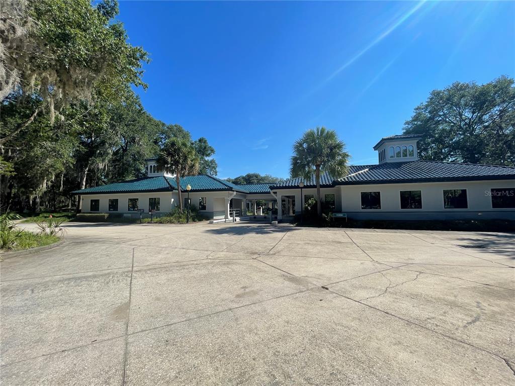 A low-rise building with a blue tiled roof and a large concrete parking area — 4500 NW 27TH AVENUE UNIT B-2, GAINESVILLE, FL