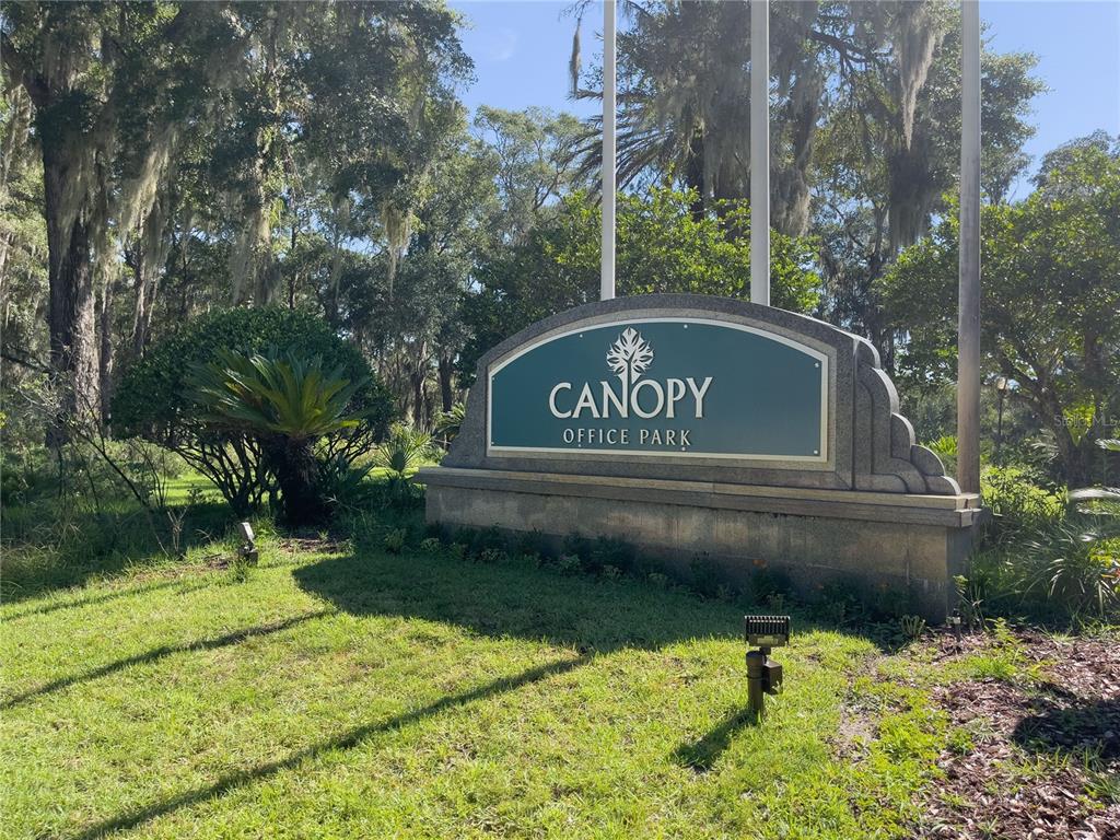 A stone sign for Canopy Office Park stands in a grassy area with trees — 4500 NW 27TH AVENUE UNIT B-2, GAINESVILLE, FL