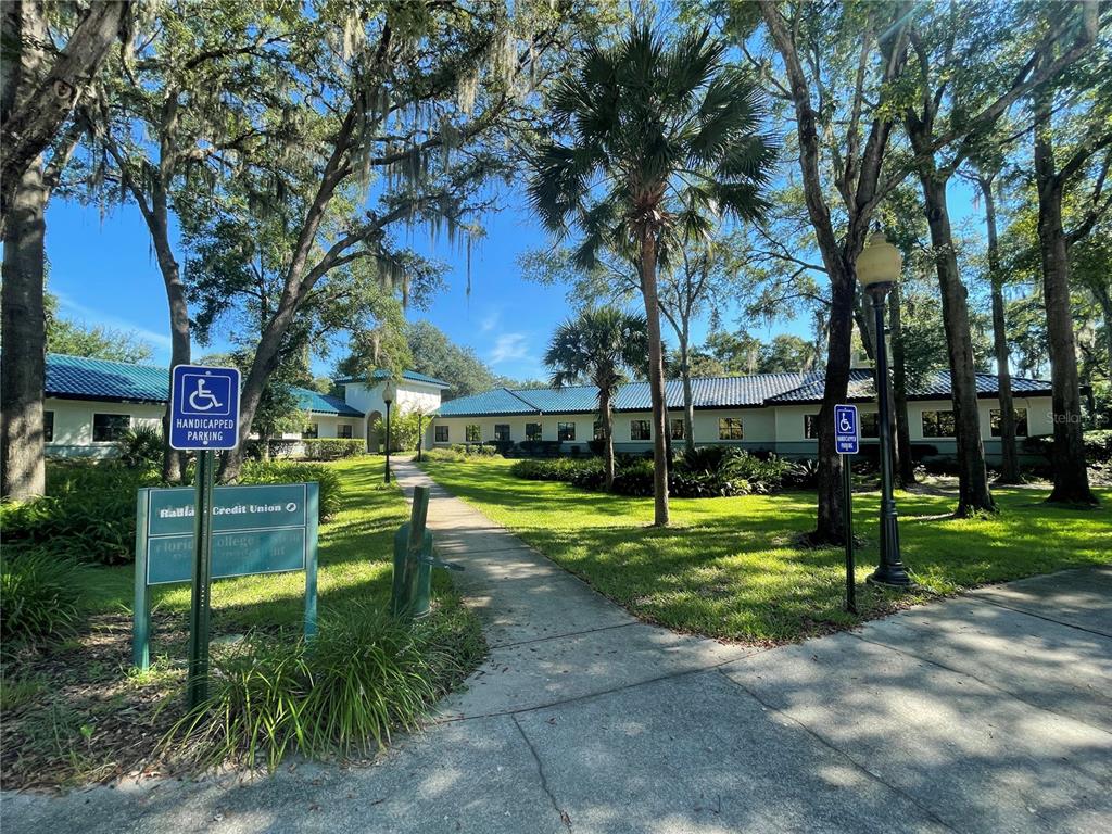 A single-story building with a blue tile roof sits behind a sidewalk and trees — 4500 NW 27TH AVENUE UNIT B-2, GAINESVILLE, FL