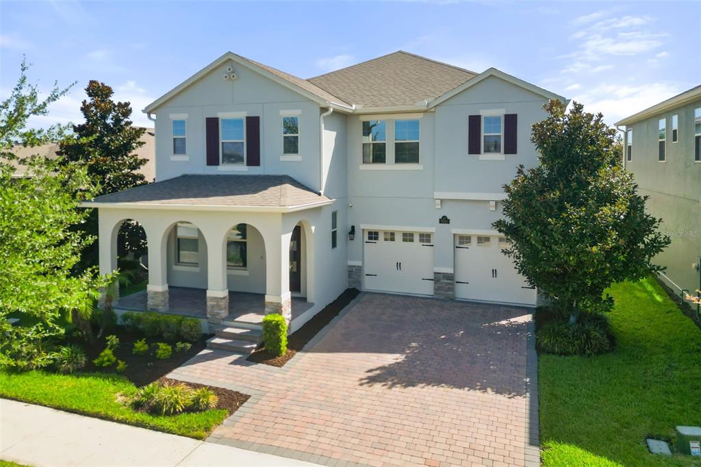 A two-story house with a paved driveway, a covered front porch, and a two-car garage — 9561 WATERWAY PASSAGE DRIVE, WINTER GARDEN, FL