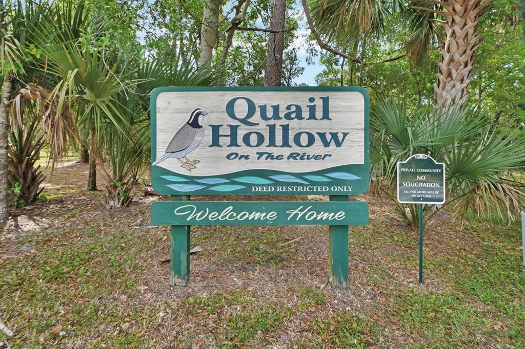 A sign for Quail Hollow On The River stands in a wooded residential area — 2701 KINGFISHER VILLAGE, DELAND, FL